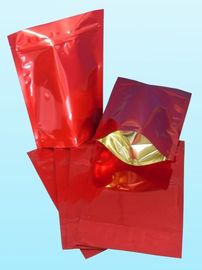 光沢のある明白で赤いホイルの袋の包装はコーヒー豆を擁護します
